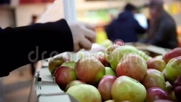 超市顾客在水果部挑选苹果分散注意力视频的预览图
