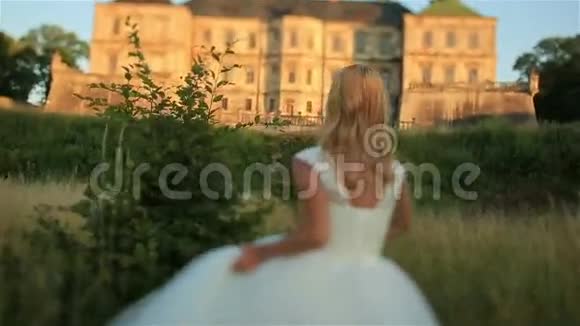 美丽的年轻金发新娘在西乌克兰的中世纪古堡摆姿势视频的预览图