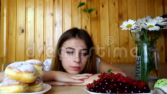 一个年轻女孩坐在桌子旁寻找食物节食视频的预览图