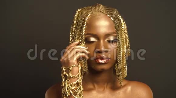 反射光彩照人的非洲裔美国妇女与明亮的金色化妆肖像青铜体彩视频的预览图