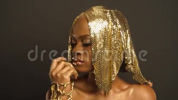 神秘的非洲裔美国妇女摄影棚的肖像用金色的脸艺术预拍拍摄用Stylist创意创意视频的预览图