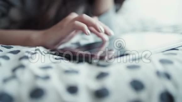 女人躺在床上用手指触摸数字平板电脑从上面看视频的预览图