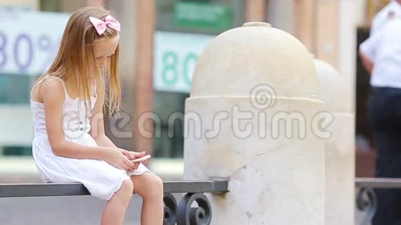 在欧洲著名的FontanadiTrevi附近的欧洲城市一个温暖的户外携带手机的可爱小女孩视频的预览图