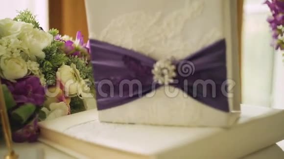 两个结婚戒指在垫子上系着丝带和其他属性视频的预览图