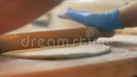 手面包师在桌子上擀面团以便在餐馆里烤馅饼视频的预览图