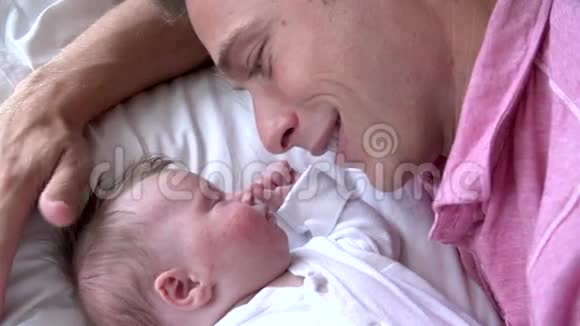 父亲在床上亲吻女儿的慢动作序列视频的预览图