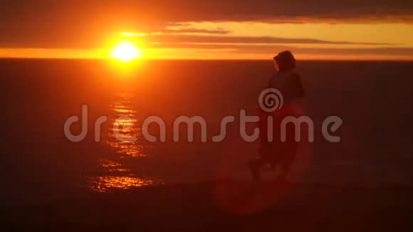 在美丽的夕阳下跳舞的女孩在大海里跳舞视频的预览图