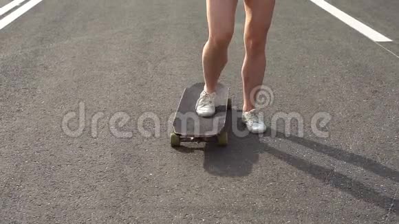 年轻迷人的女孩骑着长板慢动作视频的预览图
