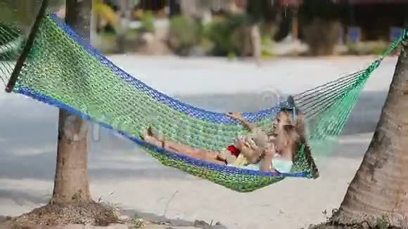 可爱的小女孩在沙滩吊床上放松视频的预览图