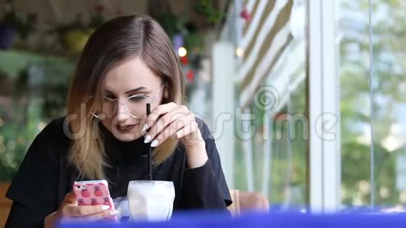 年轻迷人的女子微笑着在咖啡馆拍照视频的预览图