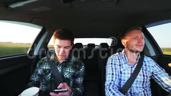 两个人开车喝着咖啡用电话微笑着视频的预览图