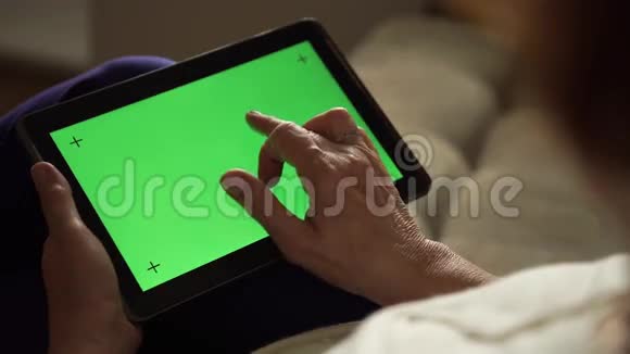 老年妇女使用带有绿色屏幕的数字平板电脑视频的预览图
