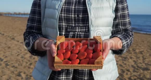 女人手里拿着装满成熟草莓的木箱视频的预览图