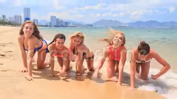 穿着比基尼的拉拉队在沙滩上微笑视频的预览图