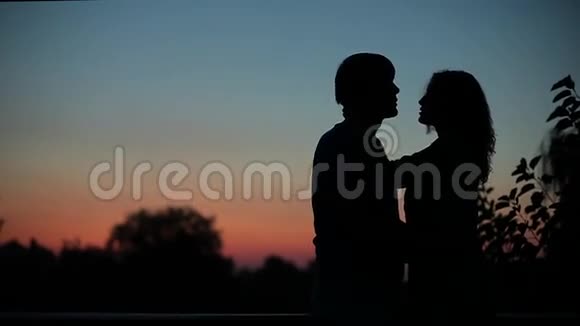 日落时接吻的情侣剪影视频的预览图