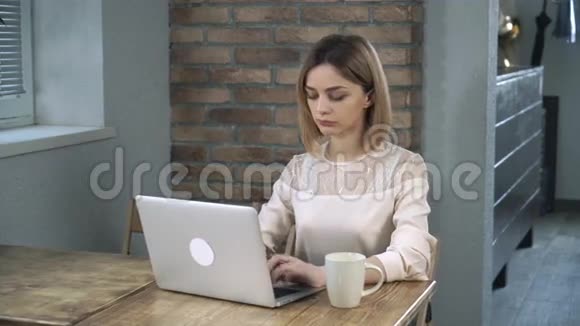 年轻的女办公室职员在电脑上打字喝咖啡视频的预览图