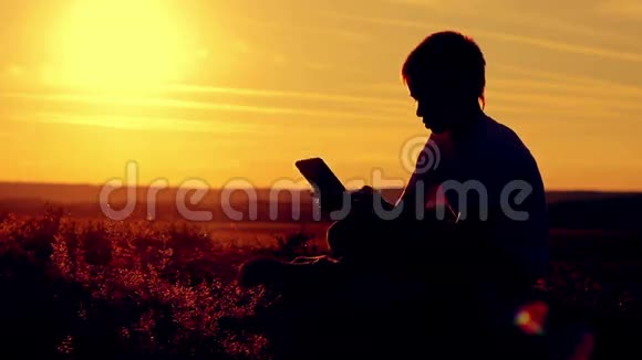 日落时分一个男孩坐在桌上视频的预览图