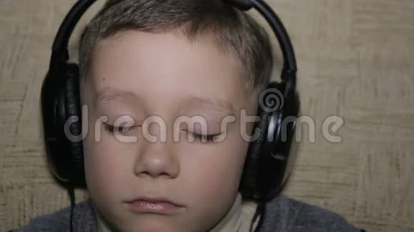 男孩通过耳机听音乐视频的预览图