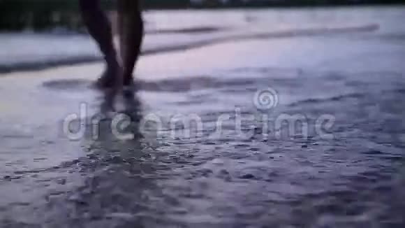 女孩在日落时在水上散步视频的预览图