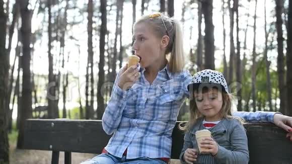 快乐的妈妈和小女儿在长凳上吃冰淇淋视频的预览图