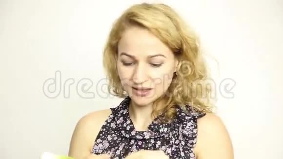 美丽的年轻女人吃蔬菜拿着青葱健康食物健康身体概念视频的预览图