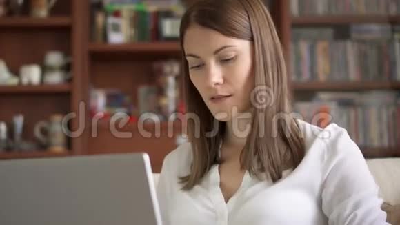 迷人的微笑职业女性在家工作笔记本电脑家庭办公概念视频的预览图