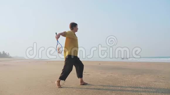 资深女士在沙滩上练习太极气球球视频的预览图