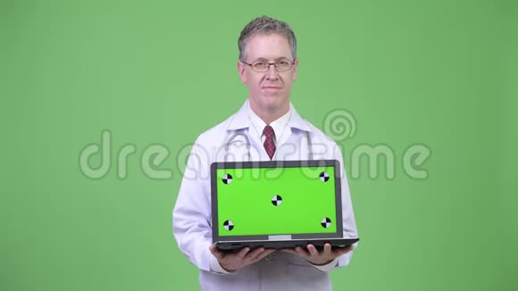 快乐成熟男医生展示笔记本电脑的画像视频的预览图