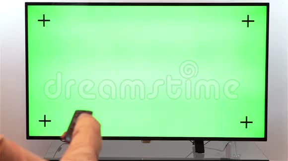 女子手与电视远程切换频道在绿色屏幕电视视频的预览图