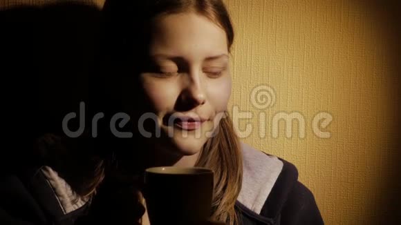 可爱的青少年女孩在家喝咖啡或茶视频的预览图