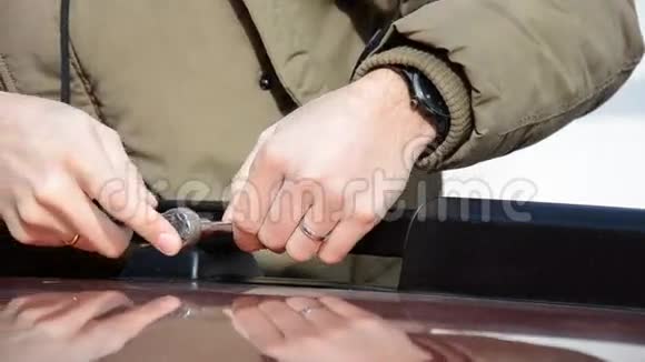 用棘轮扳手将一名中甲男子的螺丝固定在车轨机架上视频的预览图