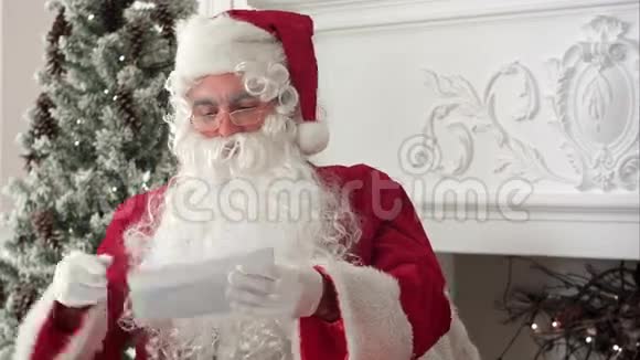 圣诞老人坐在他的车间里读一封信视频的预览图