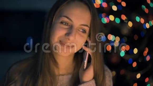 年轻漂亮的微笑女人在手机上说话视频的预览图