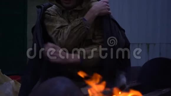 无家可归的人在火前的肖像特写视频的预览图
