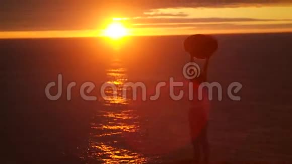 在美丽的夕阳下跳舞的女孩在大海里跳舞视频的预览图