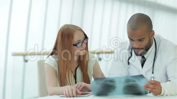 医生坐在桌边与病人交谈视频的预览图