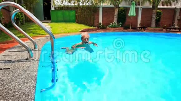 大胡子老人沿着椭圆形城市游泳池游泳视频的预览图