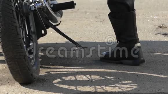 一个男人的腿试图启动一个黑色摩托车视频的预览图
