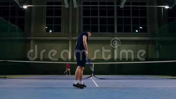 由职业网球运动员发球网球服务于泰尼斯大厅的室内带着榫头球拍上桌的人视频的预览图