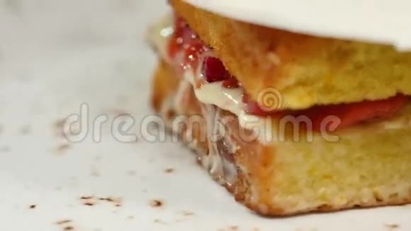 带草莓的海绵蛋糕果酱和鲜奶油配切块特写视频的预览图