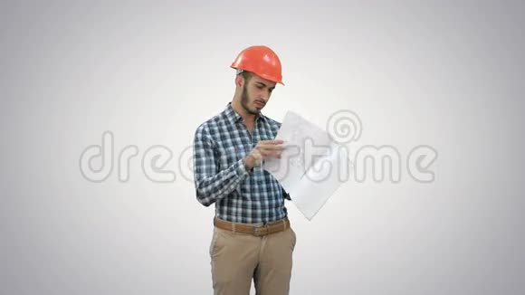 年轻工程师在白色背景上检查头盔施工计划视频的预览图