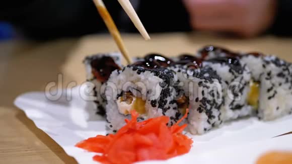日本餐馆里的女人吃寿司卷配筷子视频的预览图