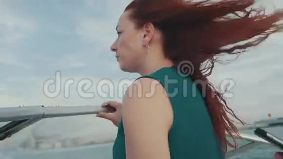 红发少女穿着绿松石服饰驾驶摩托艇夏日之夜风视频的预览图
