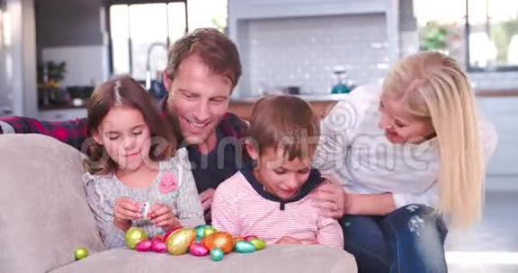 孩子们坐在沙发上和父母吃复活节彩蛋视频的预览图