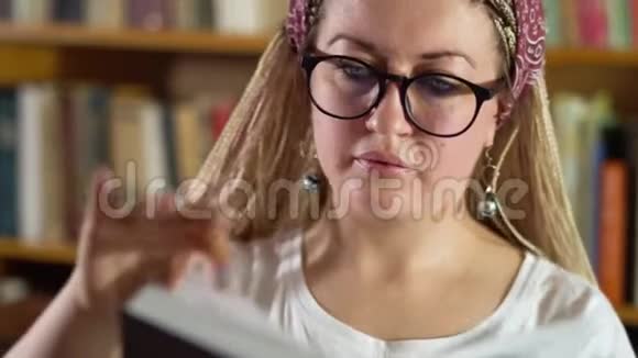图书馆里戴着眼镜的漂亮金发女郎视频的预览图