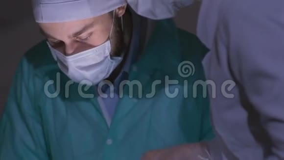 医生外科医生在手术室里给病人做手术然后向下倾斜外科小组在医院执行手术视频的预览图