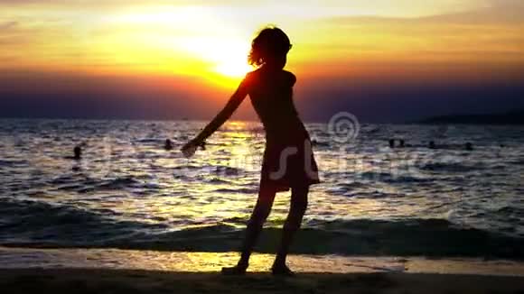 海洋日落背景下一个男孩的剪影有趣的少年男孩在日落背景下跳舞视频的预览图