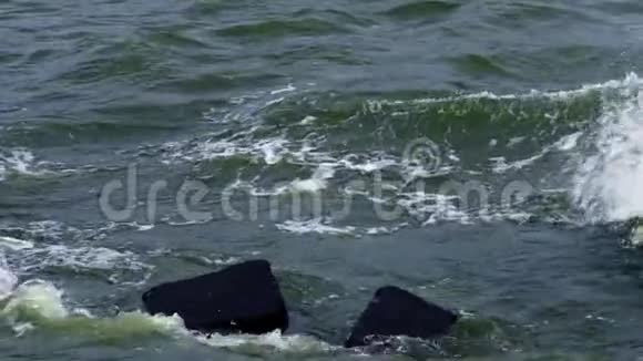 水流强烈的波浪在石头上翻滚波浪撞击岩石喷向不同方向飞行寒冷视频的预览图