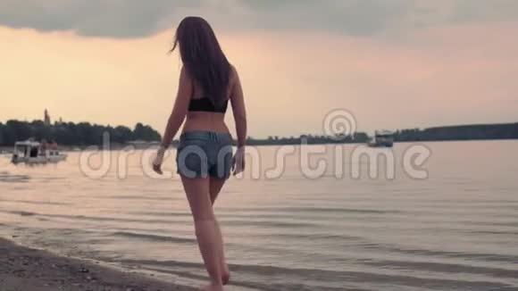 日落时分在海边散步的女孩视频的预览图