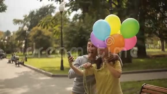 在公园里拿着气球的自拍情侣视频的预览图